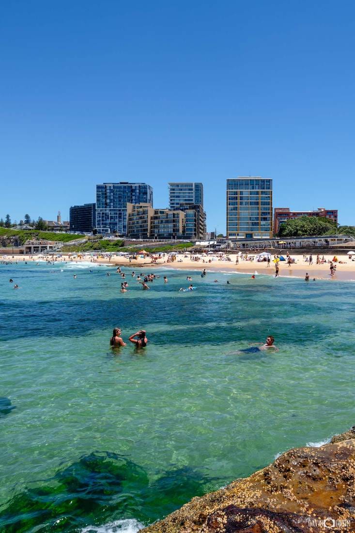 newcastle-beach-swimmers-newcastle-nsw.jpg Swimmers enjoying the clear waters of Newcastle Beach with the Newcastle city skyline in the background.