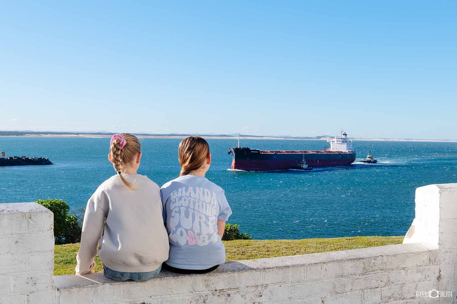 Visitors watching a coal ship entering Newcastle Harbour from Nobbys Headland.