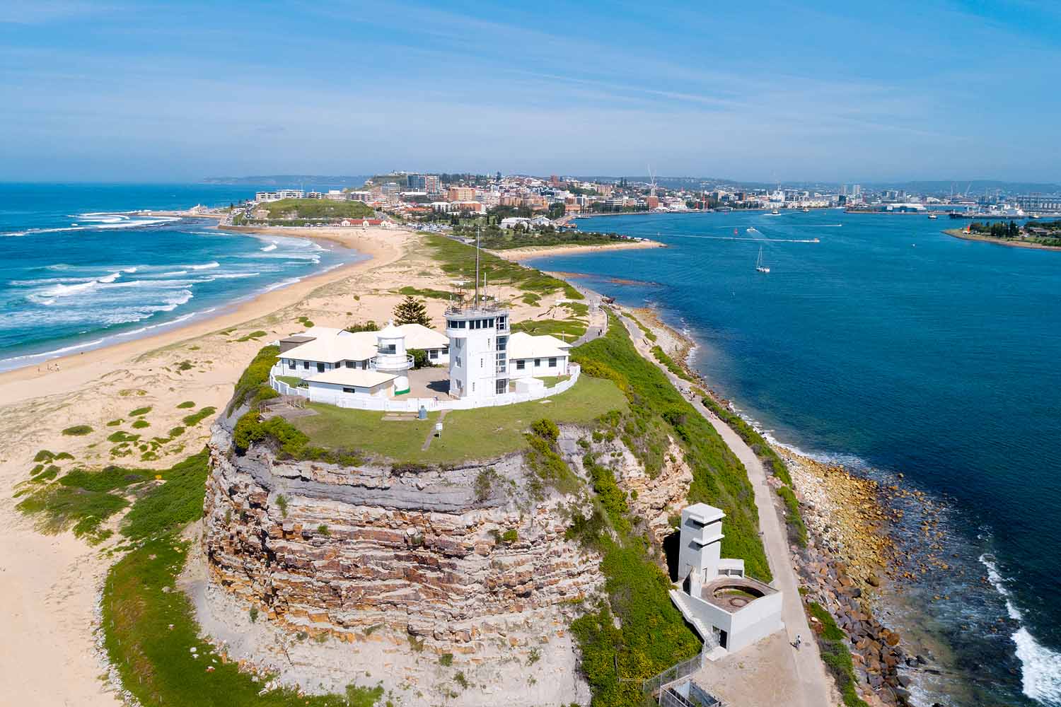 Aerial view of Nobbys Headland, Nobbys Lighthouse, Newcastle Harbour and Nobbys Beach in Newcastle NSW.