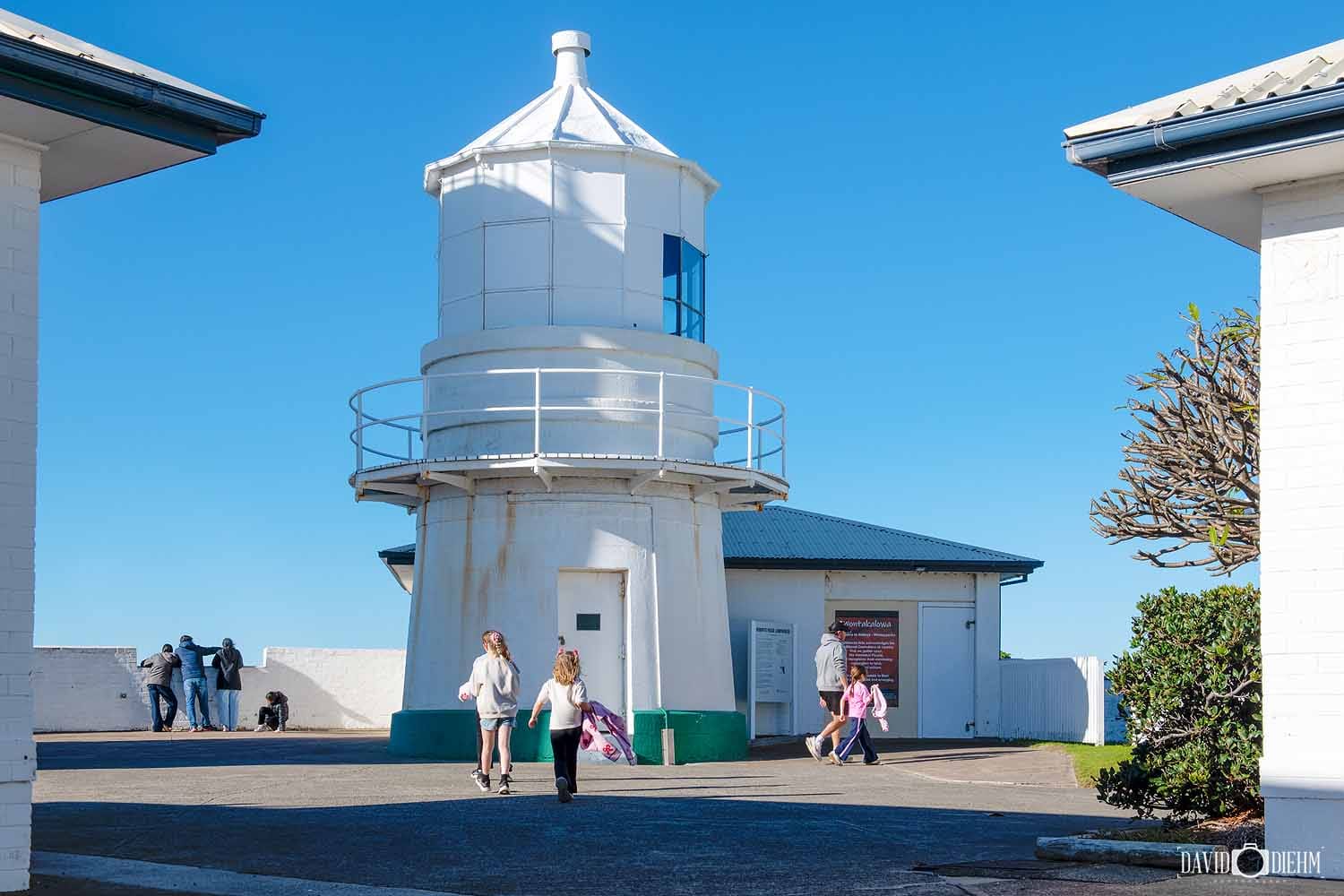 Visitors exploring the historic Nobbys Lighthouse precinct on Nobbys Headland in Newcastle NSW.