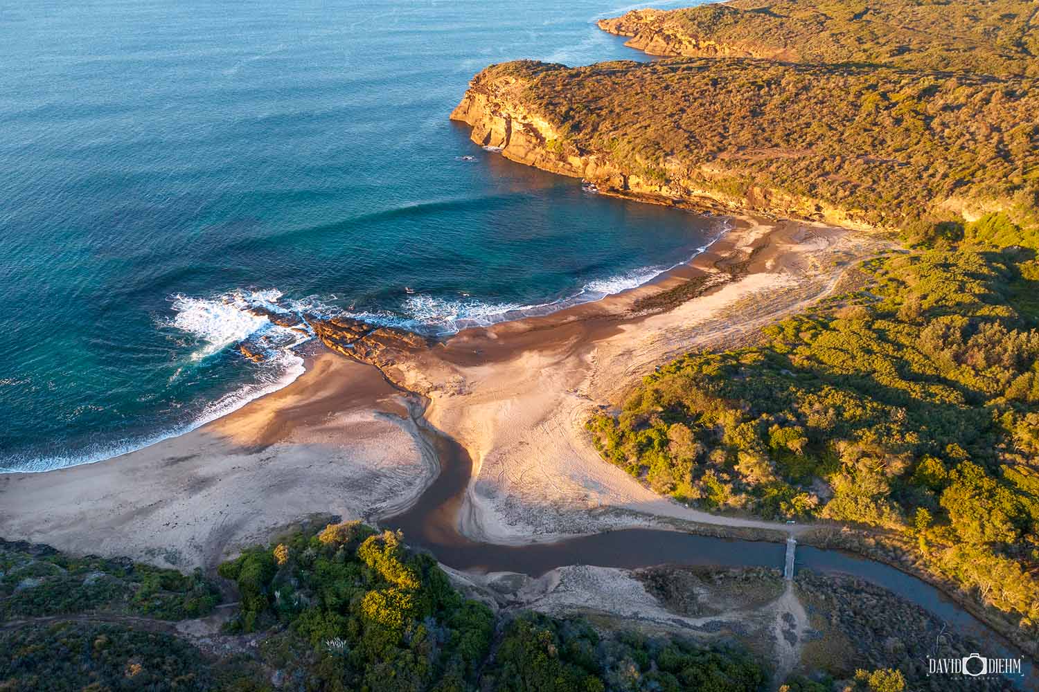 Aerial view of Pinny Beach in Wallarah National Park, Lake Macquarie, showing pristine coastline, creek entrance and surrounding bushland.
