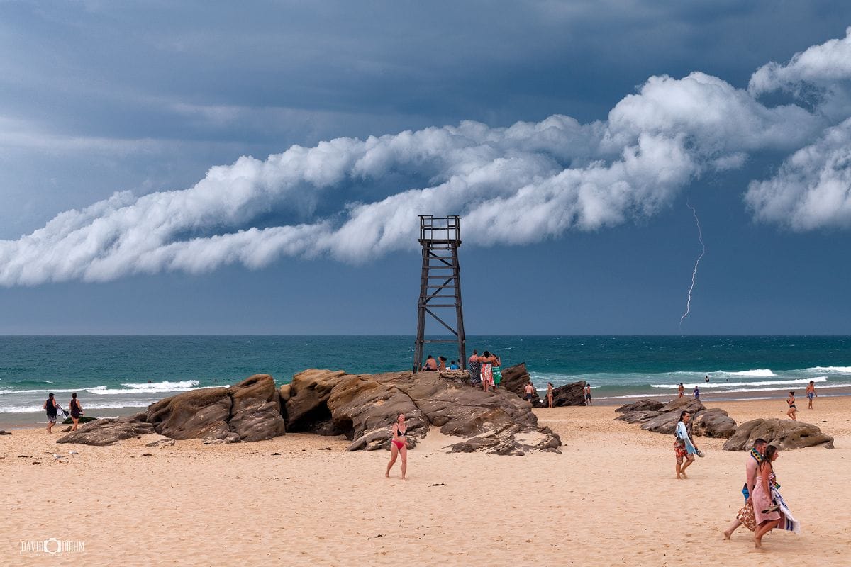 Redhead Shark Tower with approaching storm clouds and lightning over the Pacific Ocean