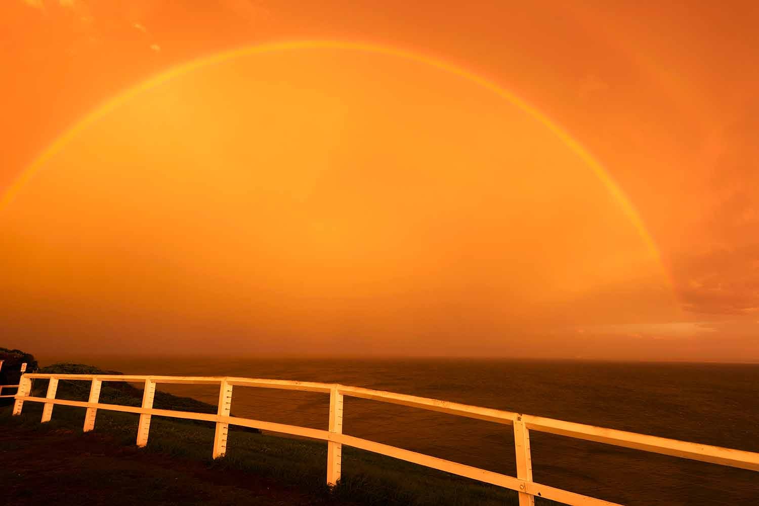 A colourful sunset and rainbow viewed from Strzelecki Lookout overlooking Newcastle city in NSW.