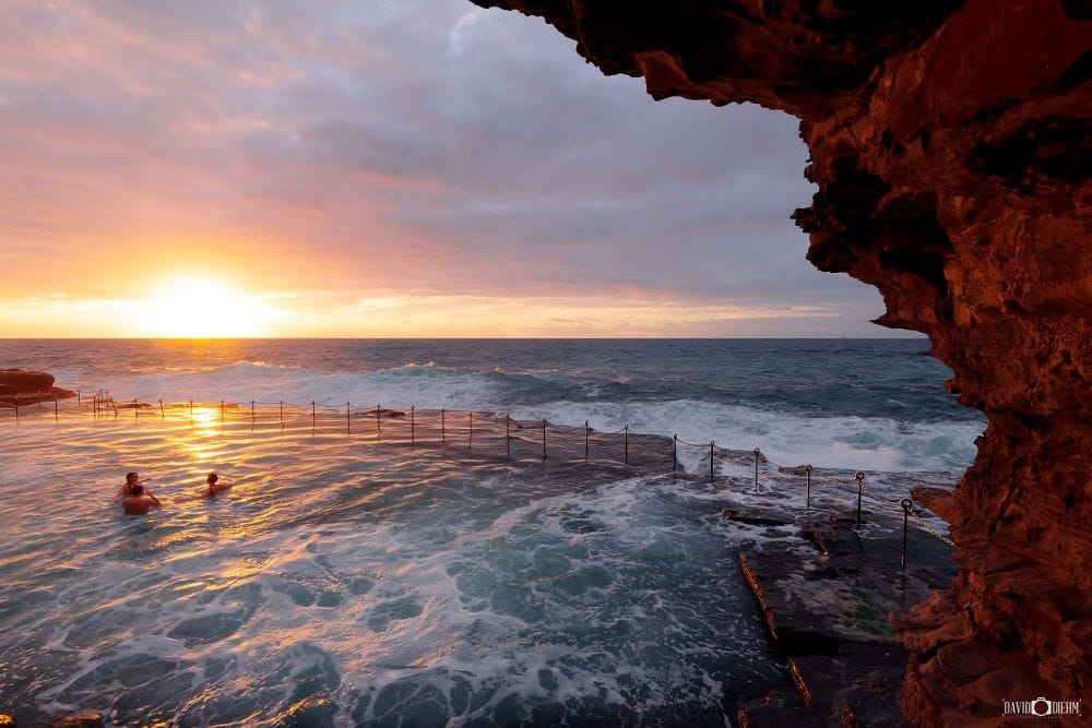 bogey-hole-sunrise-swimming-n Swimmers enjoying a sunrise swim at the Bogey Hole ocean pool beneath Newcastle's coastal cliffs.