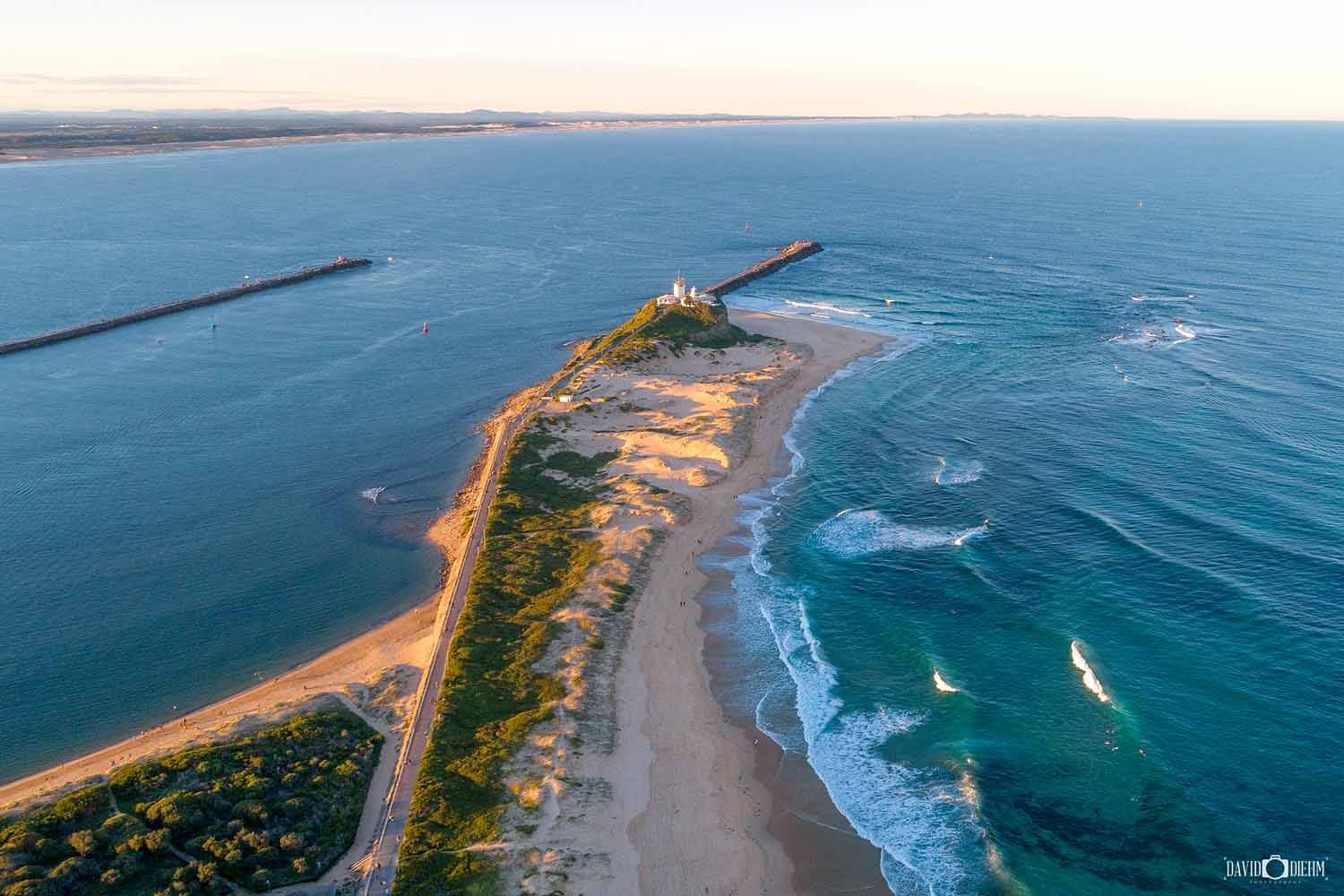 Aerial view of Nobbys Lighthouse, Nobbys Breakwall and Newcastle Harbour, NSW.