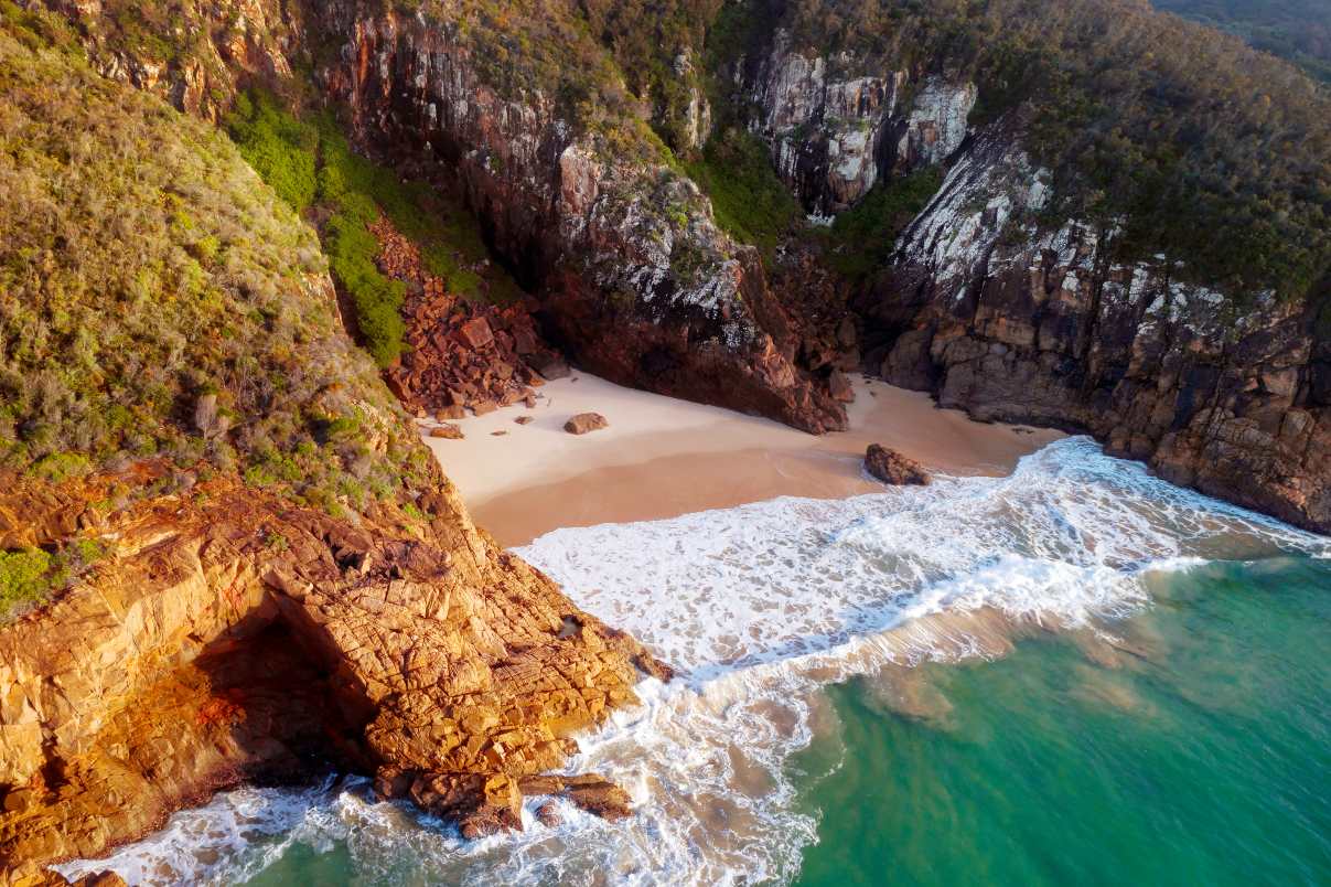 Aerial view of Wreck Beach and rugged coastal cliffs in Tomaree National Park, Port Stephens NSW