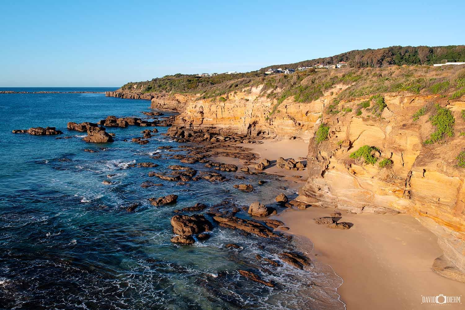 caves-beach-lookout-looking-south.jpg View looking south from Caves Beach Lookout over the sandstone cliffs and rocky coastline at Caves Beach in Lake Macquarie NSW.