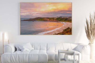 Framed wall art featuring a sunrise over Catherine Hill Bay Jetty displayed in a modern living room.
