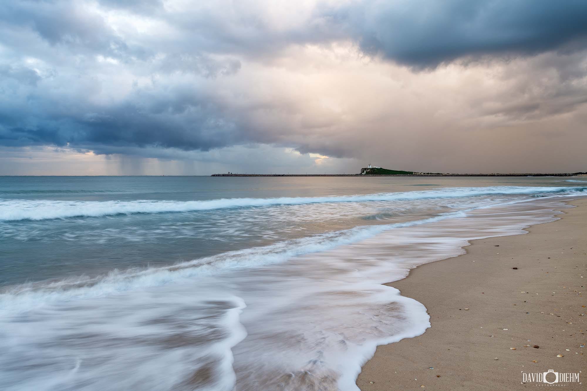 Storm clouds gathering over Stockton Beach with Nobbys Lighthouse in the distance, Newcastle NSW.