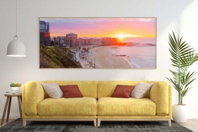 Framed panoramic wall art featuring a sunrise over Newcastle Beach displayed in a modern living room.