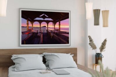 Framed wall art featuring a sunrise viewed through Nobbys Pavilion displayed in a modern bedroom.