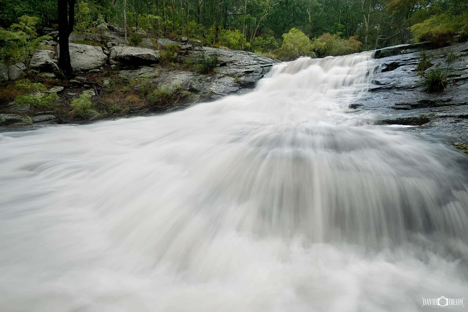 Flowing waterfall at Flaggy Creek in Glenrock State Conservation Area along the Yuelarbah Track near Newcastle NSW.