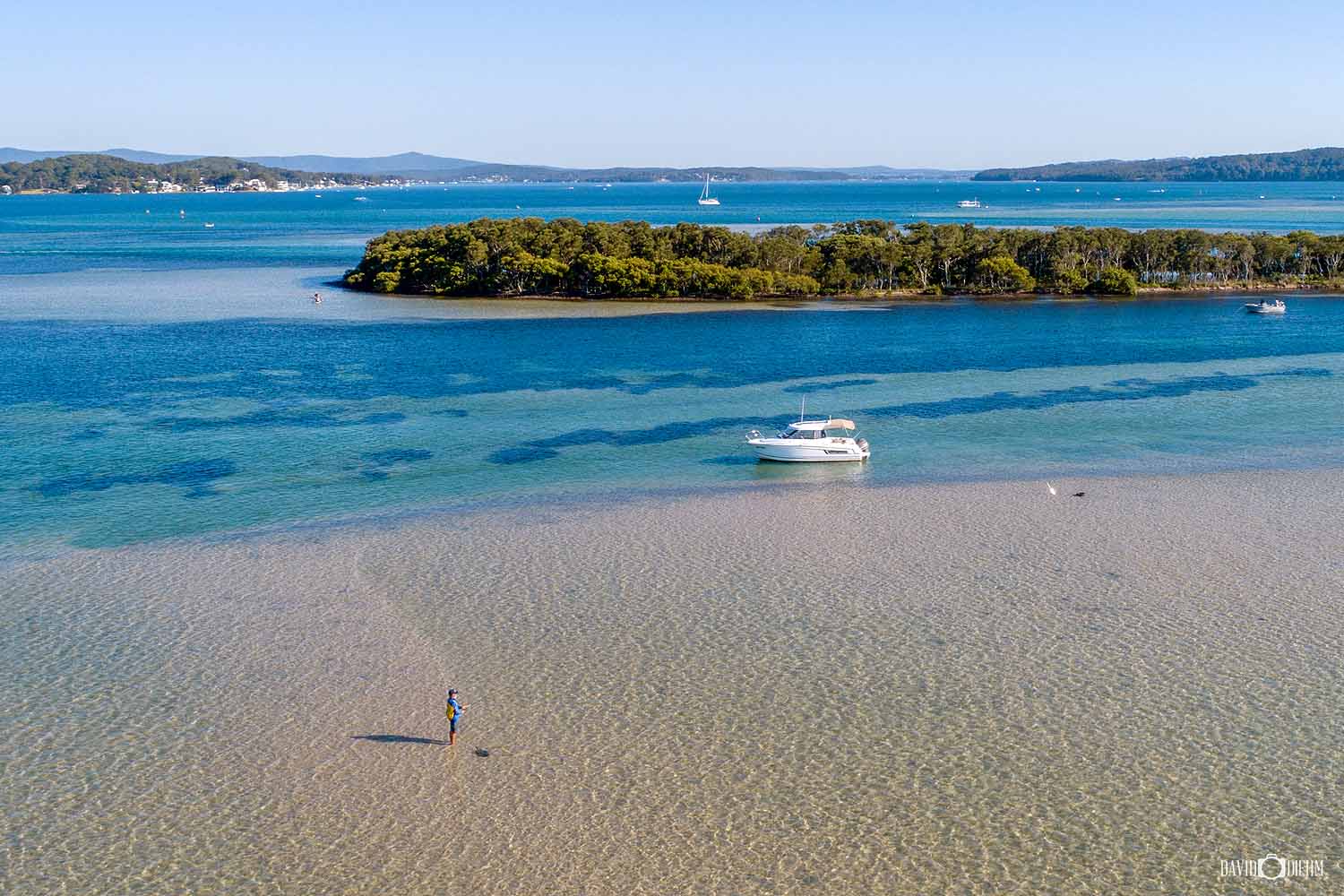 fishing-lake-macquarie-nsw.jpg Fishing in the shallow waters of Lake Macquarie with a boat and island in the background.