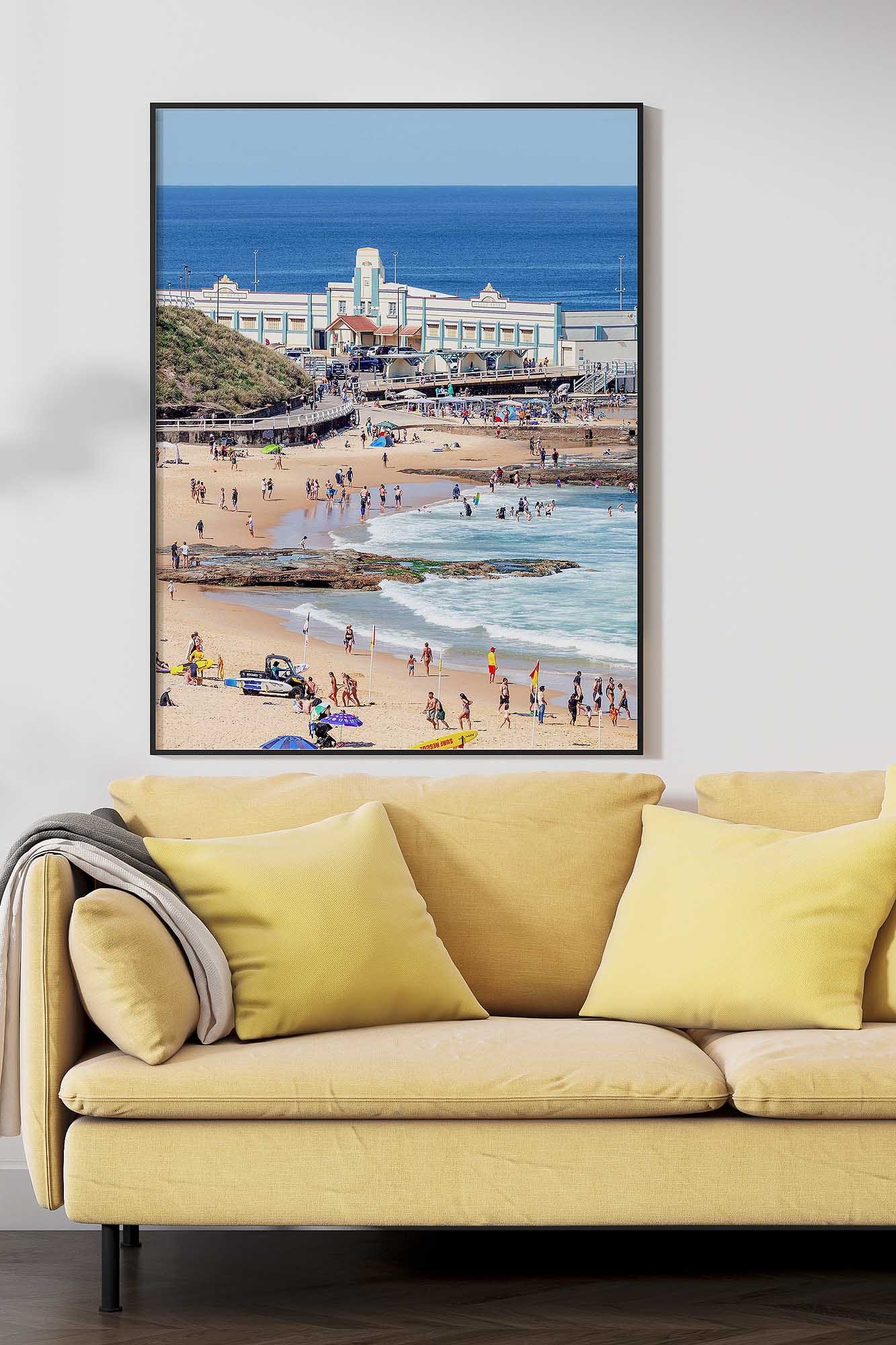 Newcastle Beach photography print showing swimmers, the coastline and historic Newcastle Ocean Baths pavilion.
