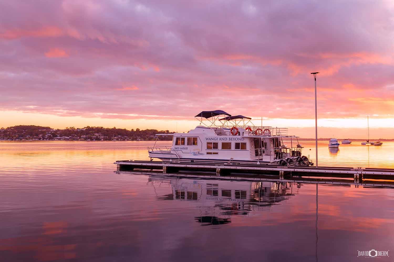 wangi-wangi-waterfront-sunset.jpg Boat moored at the Wangi Wangi waterfront during a colourful sunset over Lake Macquarie.