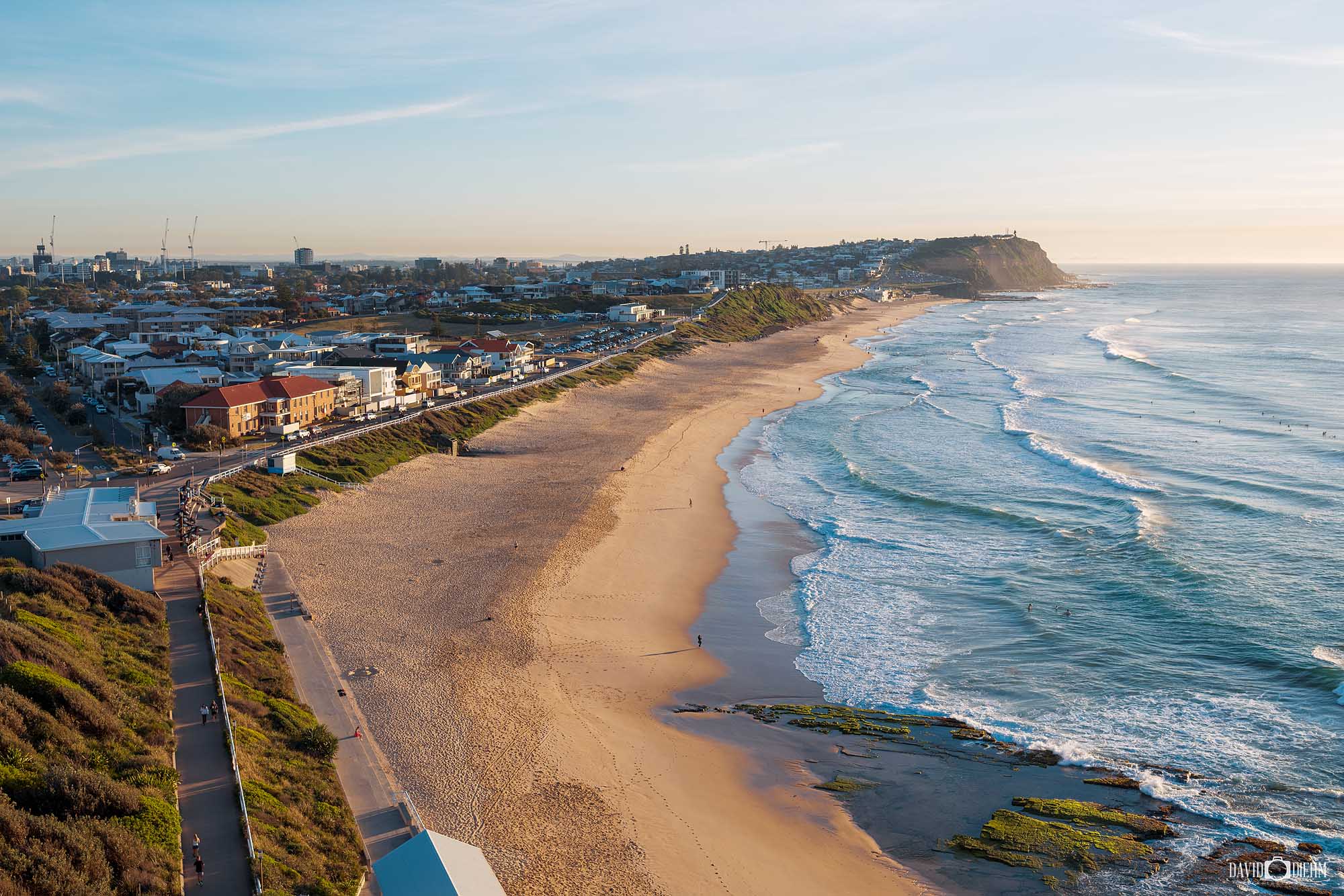 Aerial view along the Newcastle coastline from Merewether towards Bar Beach in warm morning light.