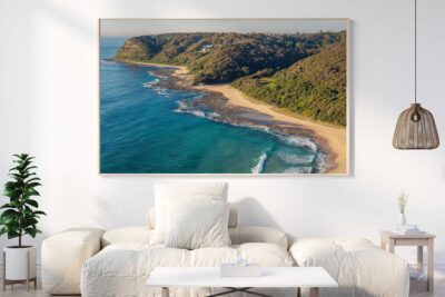 Dudley Beach Southern Shores coastal photography print in a natural timber frame above a white sofa in a modern living room.