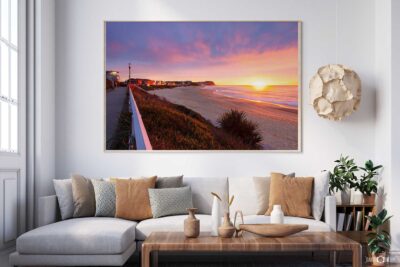Framed fine art photograph of a colourful Merewether Beach sunrise displayed above a lounge in a contemporary living room.